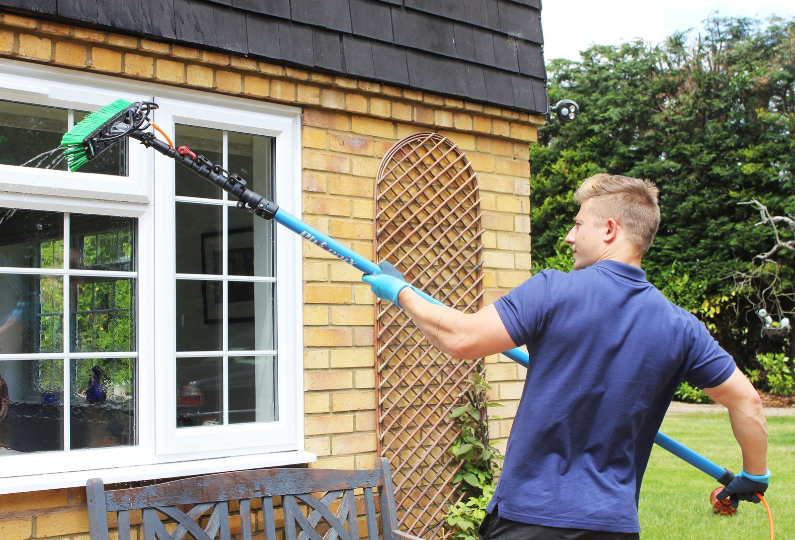 Astro Clean technician pure-water cleaning windows with a reach-and-wash pole